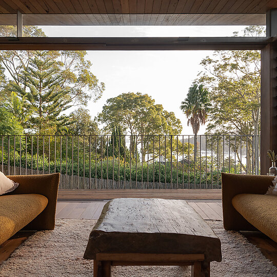 Interior photograph of Bayview Tree House by The main living area is oriented north, affording views toward Pittwater through the trees. Photographer: Luke Shadbolt